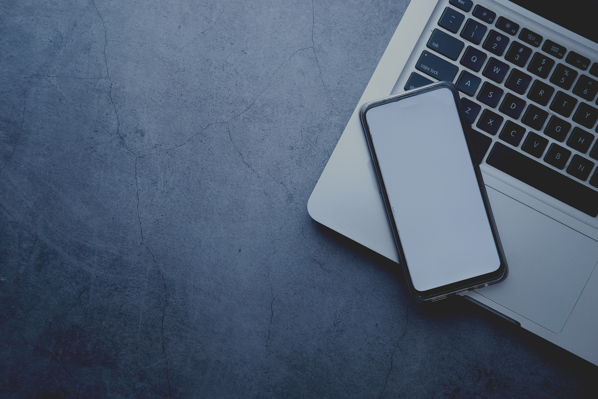 Top View of Smart Phone with Empty Screen and Laptop on Gray Background